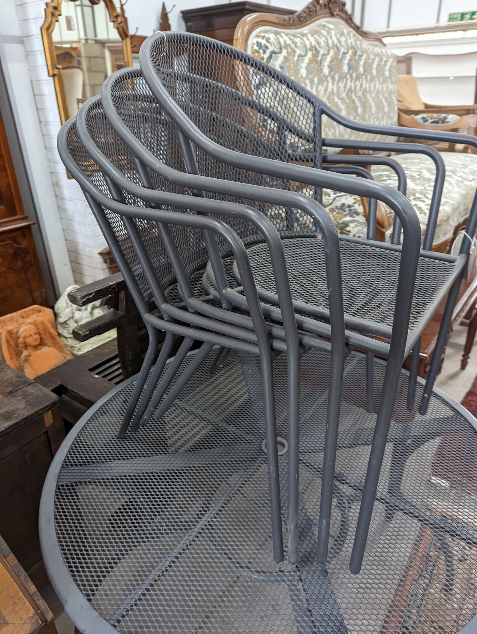 A painted and aluminium wirework circular garden table, diameter 110cm and four chairs